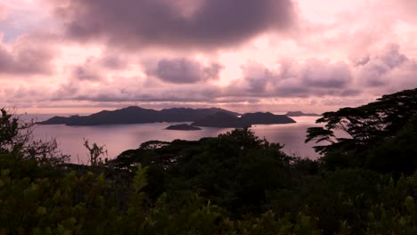 Scenic-sunset-view-on-top-of-a-mountain-on-La-Digue,-an-island-in-the-Seychelles-in-the-Indian-Ocean,-with-some-smaller-islands-in-the-background