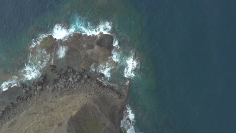 Drone-top-down-shot-of-waves-bounce-on-rocks-at-the-rocky-coast
