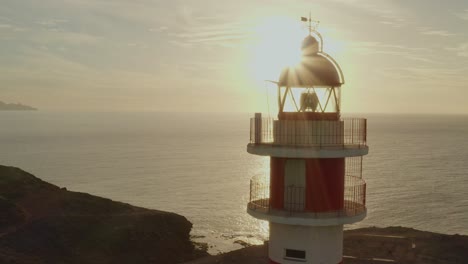 Drone-shot-of-a-lighthouse-with-sun-and-ocean-in-the-background