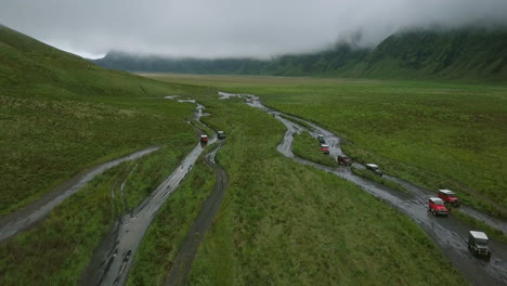 Aerial-drone-above-land-cruiser-jeeps-driving-along-a-scary-road-in-Mountain-Bromo