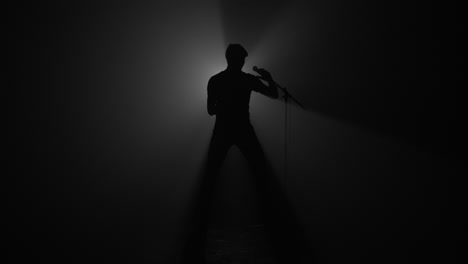 Silhouette-of-male-pop-singer-with-microphone-stand