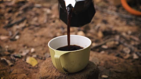 Pouring-coffee-in-cup-at-camp-site-in-the-wild