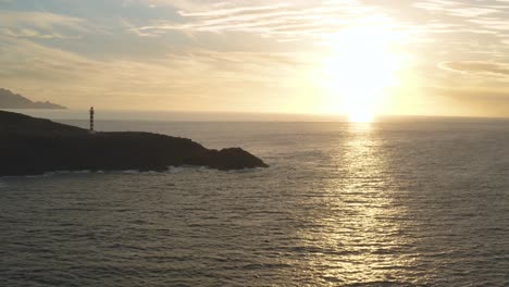 Panoramadrohnenaufnahme-Eines-Leuchtturms-Zur-Goldenen-Stunde-Mit-Sonne-Und-Meer