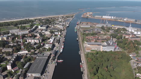 Vista-Aérea-De-Los-Barcos-De-Pesca-En-El-Canal-Del-Río-Por-El-Mar-Báltico-En-Liepaja,-Letonia