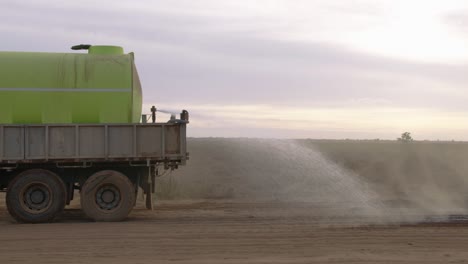 Close-Up-of-water-spray-from-a-water-truck-onto-dusty-road