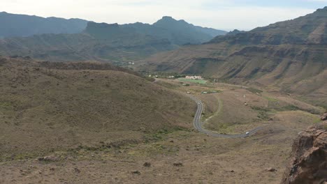 Drone-shot-of-road-in-the-background-with-a-big-rock,-gran-canaria