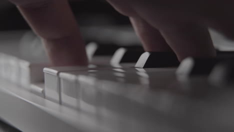 Playing-piano-keys-on-MIDI-keyboard-in-home-recording-studio