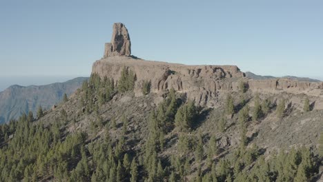 Beautiful-drone-shot-fly-over-the-roque-nublo-with-mountain-panorama-and-forest,-gran-canaria