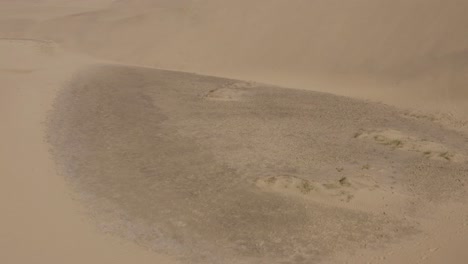 Tiro-De-Dron-De-Dunas-En-Un-Desierto-Con-Arena-Ventosa