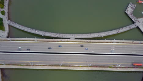 Aerial-of-cars-driving-on-a-bridge-near-river