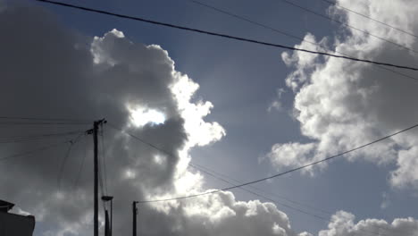 Blauer-Himmel-Mit-Einigen-Wolken,-Die-An-Der-Sonne-Vorbeiziehen