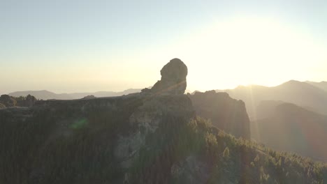 Schöne-Drohne,-Die-Zur-Goldenen-Stunde-Mit-Linseneffekt-Eines-Bergpanoramas-Mit-Wald-Von-Roque-Nublo,-Gran-Canaria,-Aufgenommen-Wurde