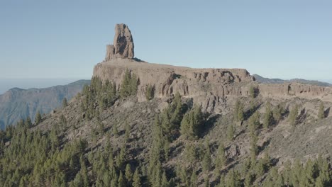 Beautiful-drone-shot-fly-over-the-roque-nublo-with-mountain-panorama-and-forest,-gran-canaria
