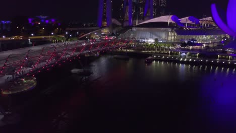 Drone-shot-of-traffic-on-a-bridge-near-river-at-night