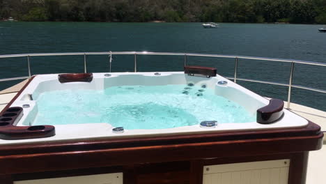Jacuzzi-on-Boat-deck-overlooking-Tropical,-Coastal-View-on-a-Sunny-Day