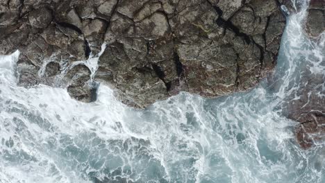 Top-shot-of-a-drone-waves-splashing-on-the-coast-of-an-ocean