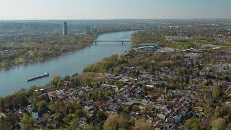 Drone---Aerial-panorama-shot-of-bonn-with-the-konrad-adenauer-bridge,-the-river-rhine-with-a-ship,-the-Kameha-Grand-hotel-and-the-post-tower-30p