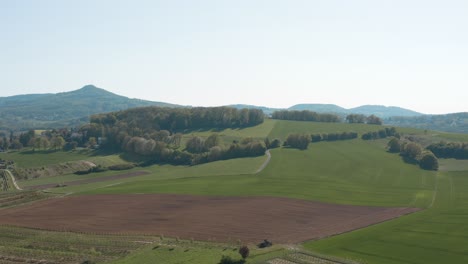 Drone---Aerial-panorama-shot-of-a-meadow-with-grass-and-bushes-and-the-Siebengebirge---seven-mountains-in-the-background-25p