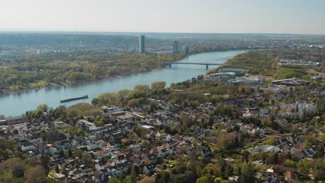 Drone---Aerial-panorama-shot-bonn-with-the-konrad-adenauer-bridge,-the-river-rhine-with-a-ship,-the-Kameha-Grand-hotel-and-the-post-tower-25p