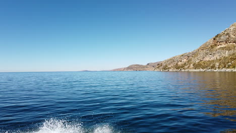 Boat-ride-in-Puno-lake-Titicaca-Peru-land-view-of-taquille-island-with-blue-sky