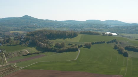 Drone---Aerial-panorama-shot-of-a-meadow-with-grass-and-bushes-and-the-Siebengebirge---seven-mountains-in-the-background-30p