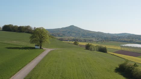 Drone---Aerial-panorama-shot-of-al-lonely-chapel-on-a-field-with-grass-and-a-road-with-panorama-of-the-seven-mountains---Siebengebirge-25p