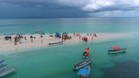 Drone-shot-tropical-sand-island-full-of-people-and-boats