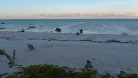 Erstaunliche-Sonnenuntergangsdrohnenaufnahme-Des-Motorradfahrens-An-Der-Küste-Der-Insel-Sansibar