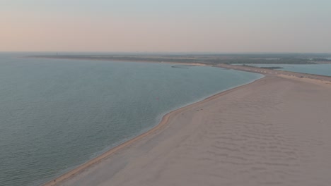 Cinematic-drone---aerial-panorama-shot-of-the-sandy-nature-beach-at-sunset-with-tourists-and-people-with-Buggykiting-at-Zeeland-at-the-north-sea,-Netherlands,-25p