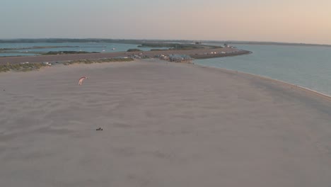 Filmische-Drone---Luftaufnahme-Vom-Sandigen-Naturstrand-Bei-Sonnenuntergang-Mit-Buggykiting-In-Zeeland-An-Der-Nordsee,-Niederlande,-30p