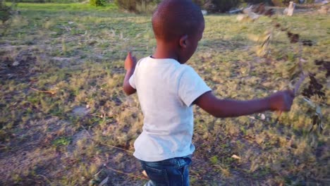 Black-boy-playing-with-a-stick-in-the-grass