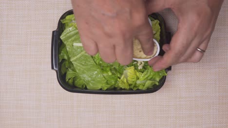 Cooks-hands-putting-heart-shaped-rice-portion-on-to-the-green-salad