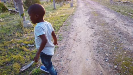 Siguiendo-A-Un-Niño-Negro-Caminando-Por-El-Camino-De-Grava