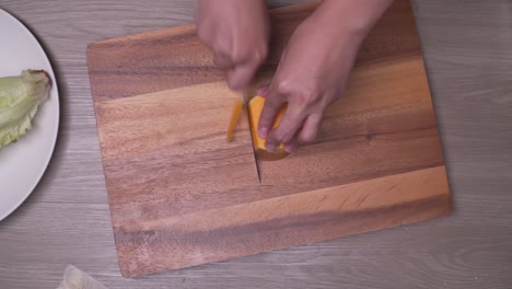 Top-view-cutting-slices-of-raw-fresh-sweet-potato-on-wooden-board