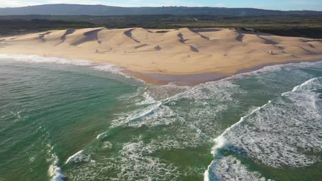 Vista-De-Drones-Volando-Sobre-Dunas-De-Arena-Junto-Al-Océano-En-Sudáfrica