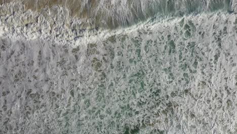 Overhead-aerial-shot-looking-straight-down-at-crashing-waves-and-surf-in-South-Africa