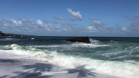 Rollende-Wellen-An-Einem-Sandigen-Ufer-Mit-Kokospalmen