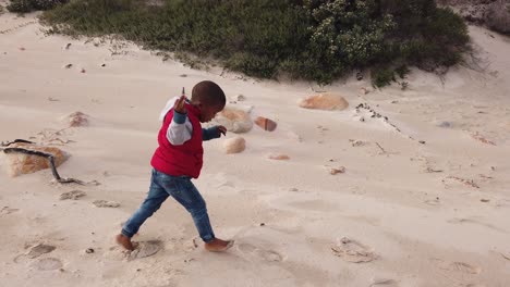 Little-boy-running-and-playing-on-the-beach-in-the-winter-time