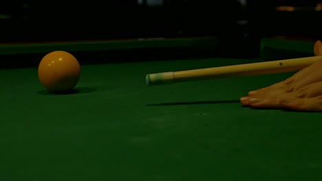 Close-up,-slow-motion,-Pool-cue-resting-on-hand-aims-and-hits-ball-on-pool-table