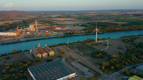 Aerial-shot-from-above-of-five-Wind-Turbines-near-a-river-in-Southern-France-at-sunset