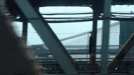 Blick-Aus-Dem-Fenster-Einer-New-Yorker-U-Bahn-In-Bewegung,-Die-über-Die-Manhattan-Bridge-Fährt,-Mit-Der-Brooklyn-Bridge-Im-Hintergrund