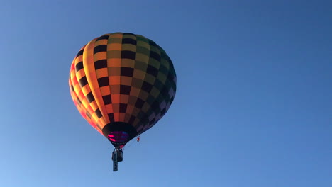 Colorful,-checkered-hot-air-balloon-floats-into-the-sky