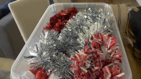 opening-a-box-of-christmas-decorations-full-of-tinsel-and-baubles