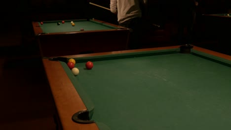 Shooting-yellow-ball-into-pool-table-pocket-and-rolling-up-and-down-table