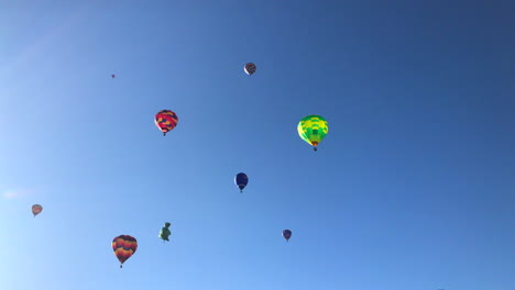 Tilt-down-revealing-sky-filled-with-hot-air-balloons