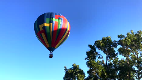 Hot-air-balloon-floats-by-trees