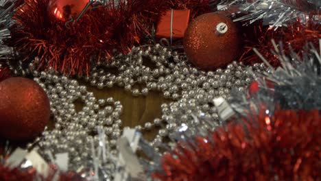 Weihnachtsschmuck-Auf-Einem-Tisch-Heranzoomen-Und-Eine-Silberne-Kugel-Aufheben