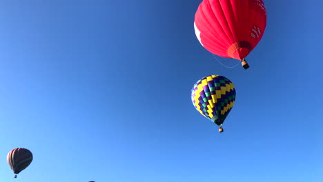 Tilt-up-revealing-sky-filled-with-hot-air-balloons-in-mass-launch