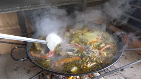 Traditionelle-Spanische-Paella,-Die-Auf-Einem-Feuer-Mit-Gemüse-Kocht