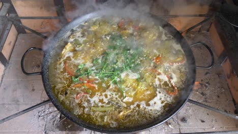 fresh-paella-with-open-fire-and-smoke,-above-view